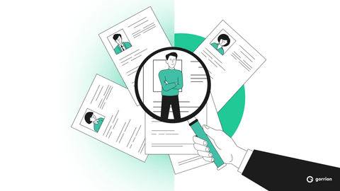 A magnifying glass over a pile of resumes